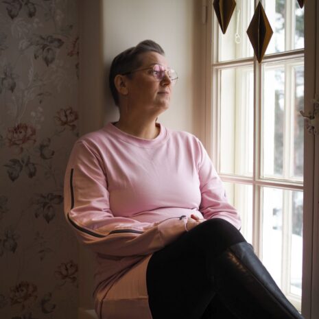 Vanha roosa sytostaattitunika, jonka hihoissa on alhaalta olkapäälle asti aukeavat vetoketjut.